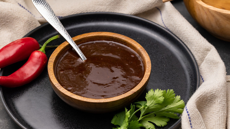 Hoisin sauce in wooden bowl with spoon