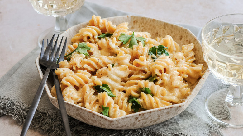 Bowl of pasta with alfredo sauce and parsley garnish