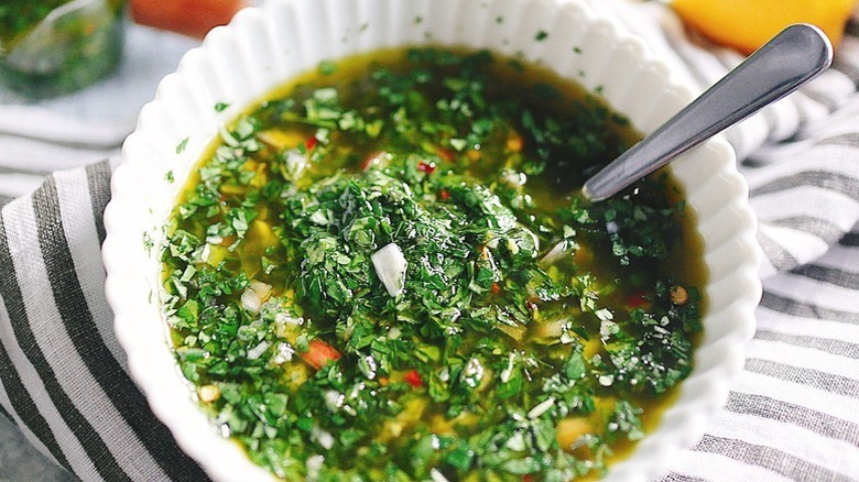 Chimichurri sauce in white bowl with spoon