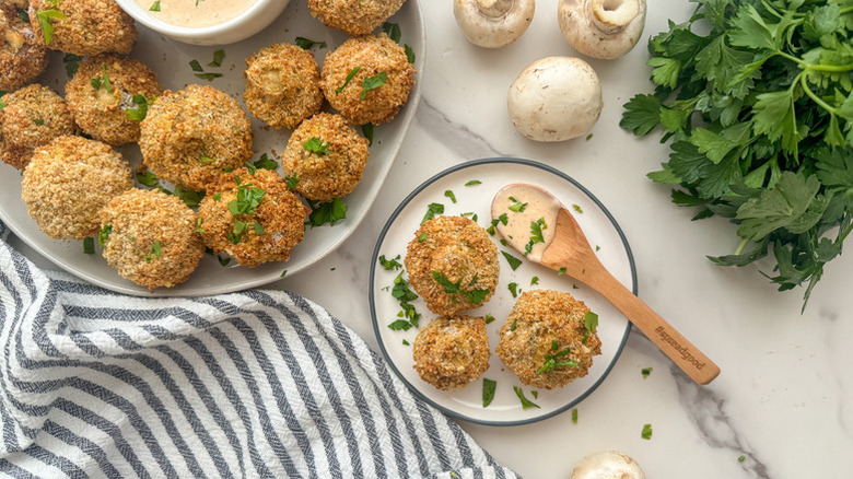 Crispy breadcrumb-coated mushrooms served onto a side plate