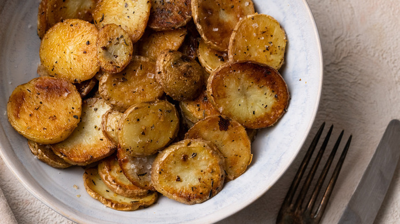Sliced fried potatoes in a white bowl