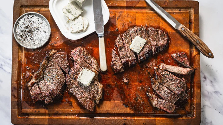 sliced garlic butter steak on cutting board