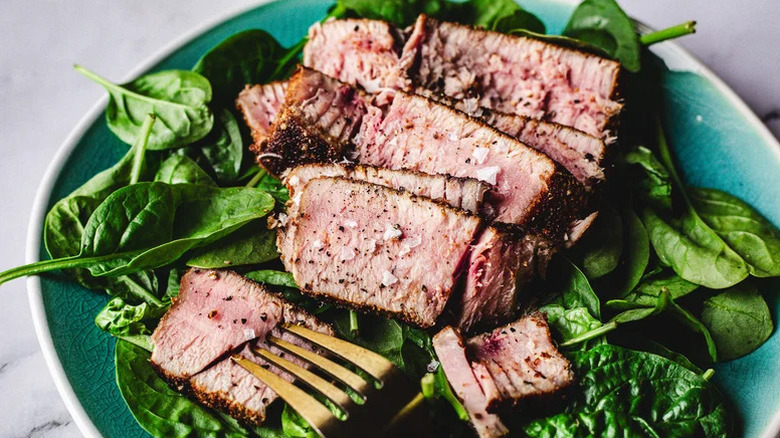 sliced grilled tuna on bed of spinach