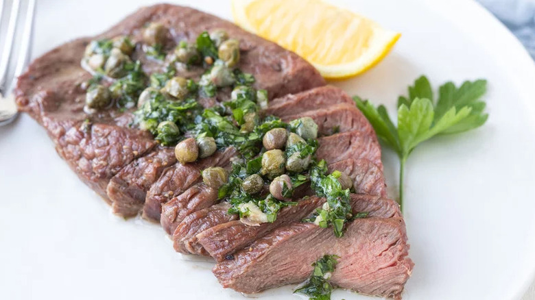sliced flat iron steak drizzled in caper marinade