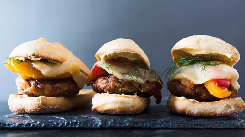 three sausage burgers side by side