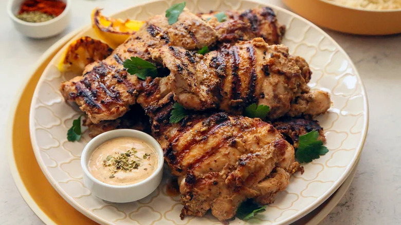 tahini marinated grilled chicken on plate with yogurt dip