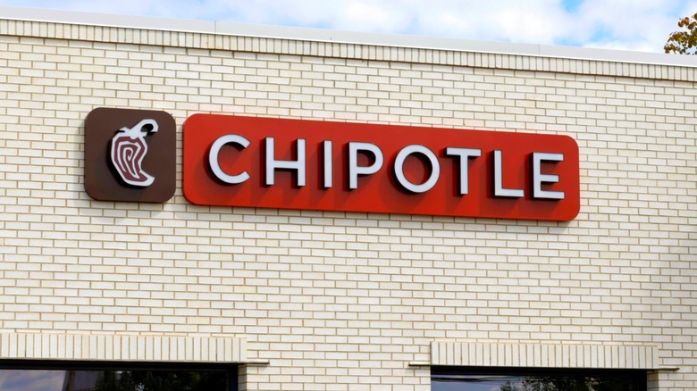 A Chipotle restaurant with red logo sign and white brick exterior