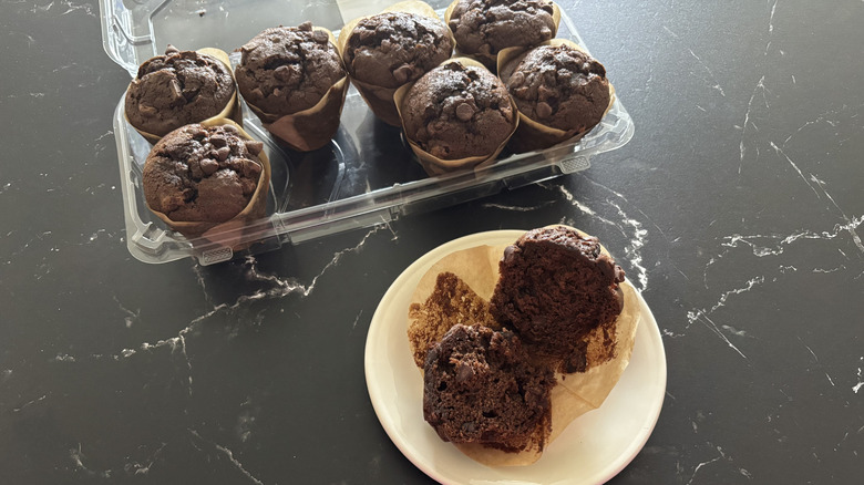 Costco triple chocolate muffin on plate with container of muffins in background