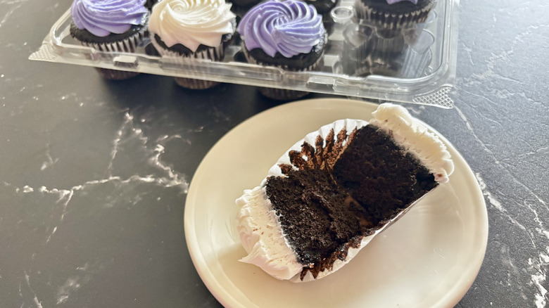 Costco chocolate cupcake on plate with tray of cupcakes in background