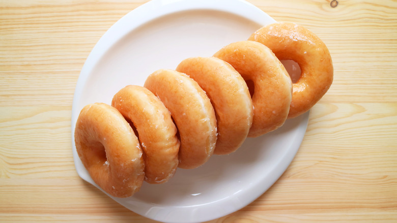 Aerial shot of glazed donuts on a white plate