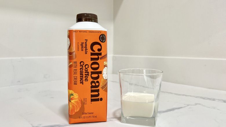 Chobani Pumpkin Spice coffee creamer poured into a cup.