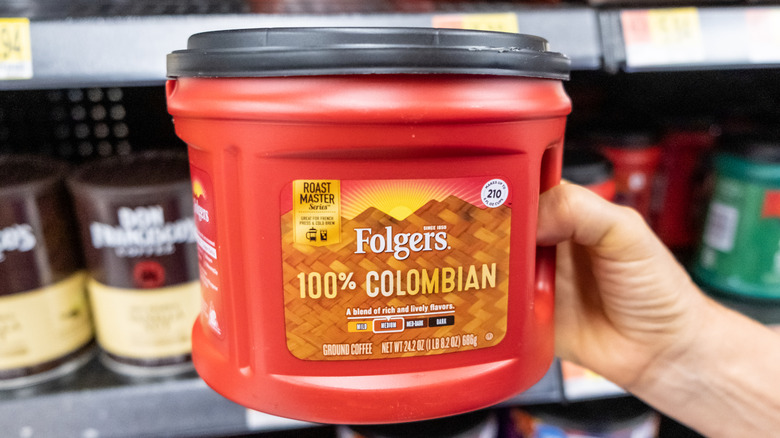 Hand holding canister of Folgers coffee in store