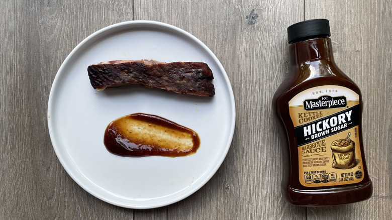 KC Masterpiece barbecue sauce bottle and rib on a plate