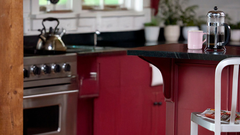 A kitchen with burgundy cabinets