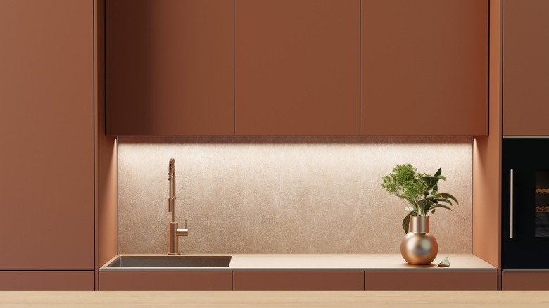 A kitchen with terracotta-hued cabinets