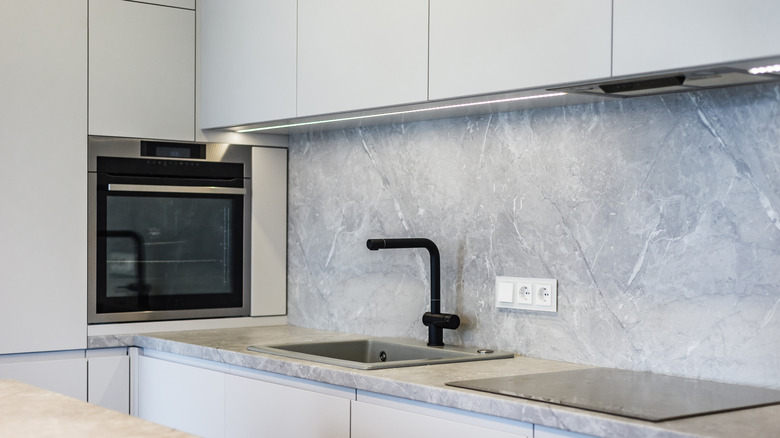 A kitchen with cool-gray cabinets and a gray backsplash