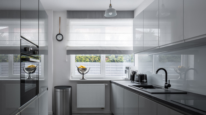 A kitchen with gray gloss cabinets