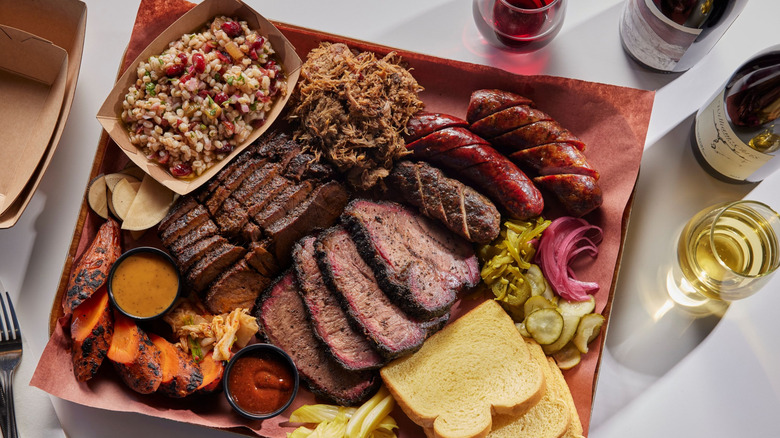 a plate of barbecue meats and glasses of wine