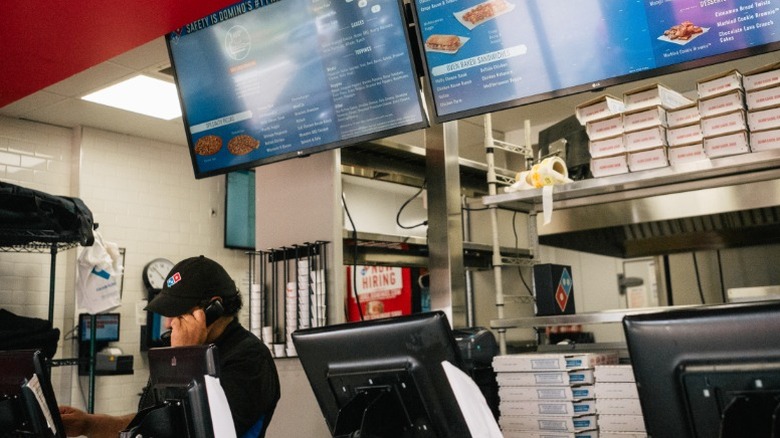 A Domino's employee takes a phone order at a restaurant in Houston