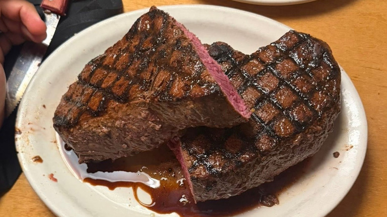 A large juicy steak on a white plate at Texas Roadhouse