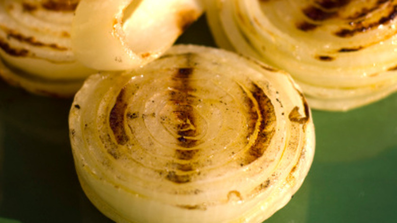 A closeup shot of grilled onions on a green base