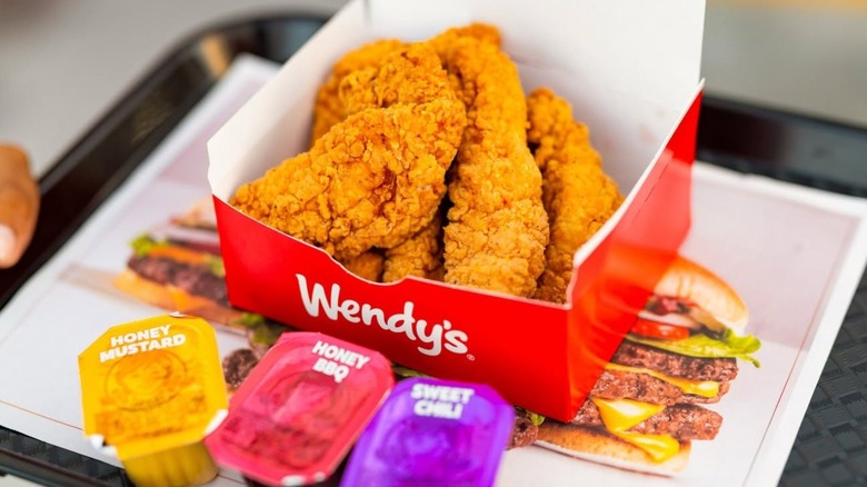 Box of Wendy's chicken tenders with dipping sauces.
