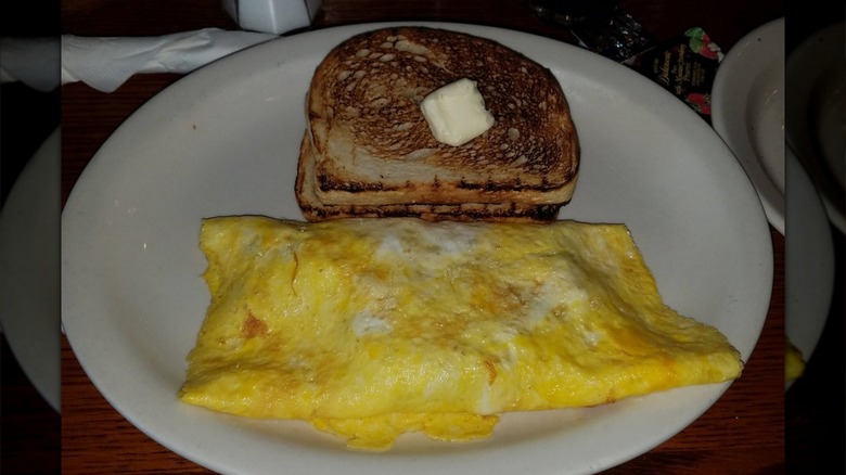 An omlete on a plate with bread from Cracker Barrel
