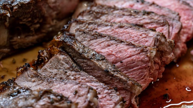 Close up of slices of steak on a wooden cutting board