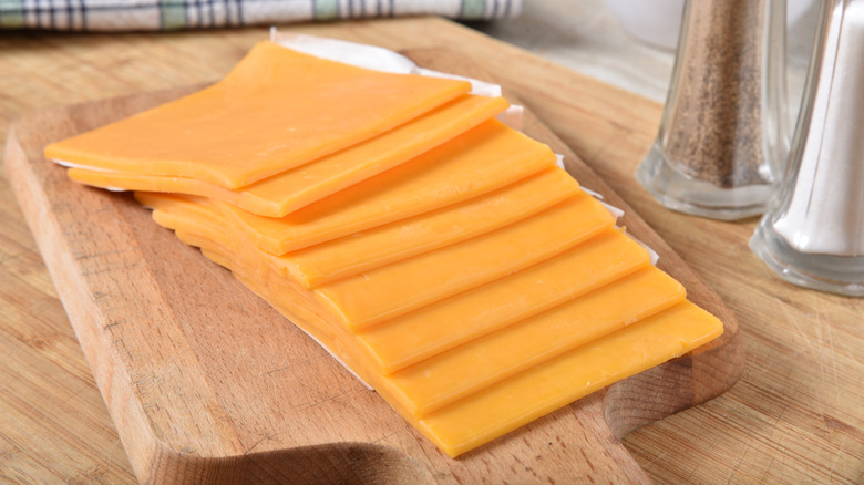 Cheese slices on a board.
