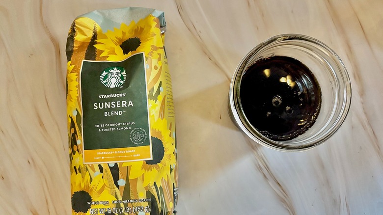 Top-down shot of Starbucks Sunsera bag next to mason jar of cold black coffee