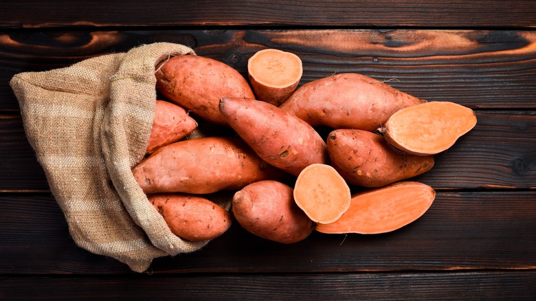 Bunch of large sweet potatoes coming out of a brown sac.