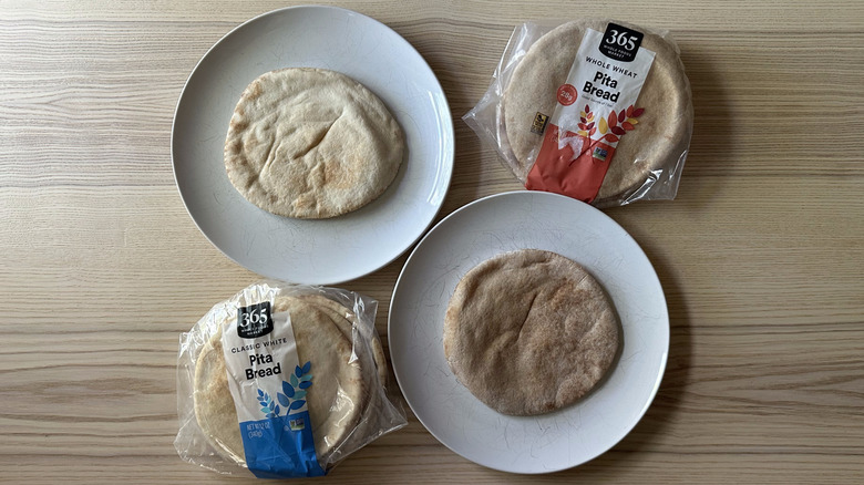 Two 365 Whole Foods Market Pita Bread varieties on wooden table with two pitas on white plates