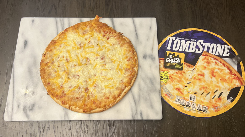 Tombstone original thin crust 5 cheese pizza on serving board.