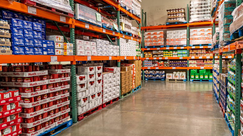 Aisle in Costco store displaying canned sauces and other food products