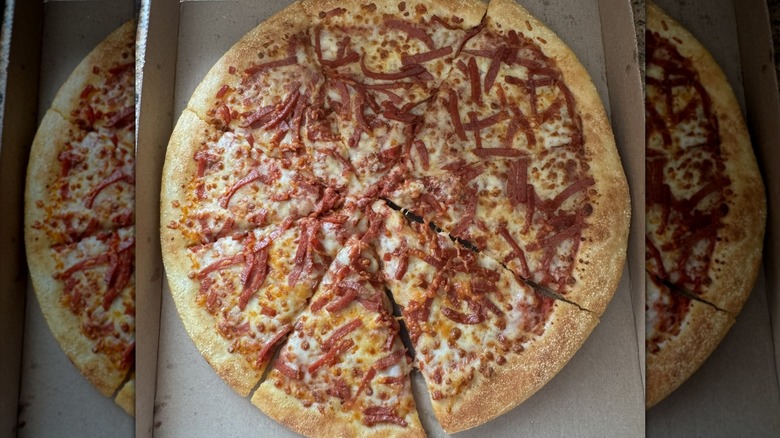 Overhead view of the Little Caesars Webberoni Pizza in a box. It's covered in shredded pepperoni and cheese