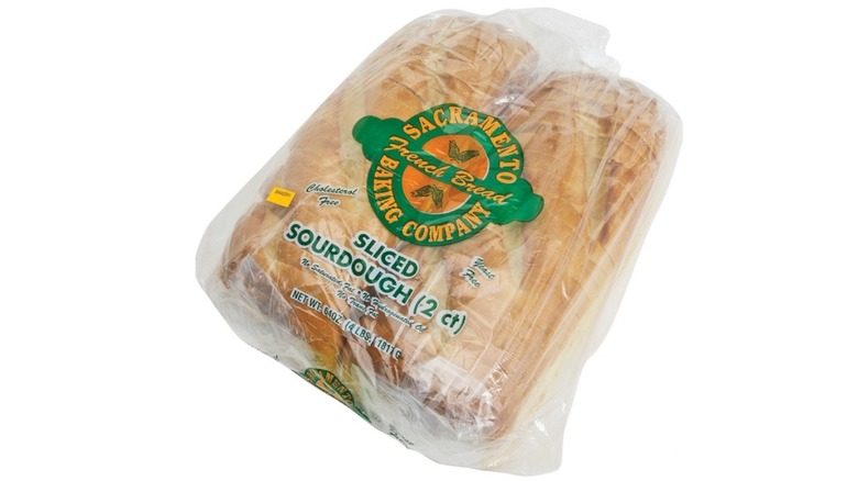 Two loaves of sliced sourdough bread in plastic bag branded with logo