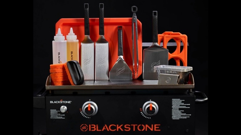 The Blackstone 25-Piece Accessory Set arranged on a Blackstone griddle
