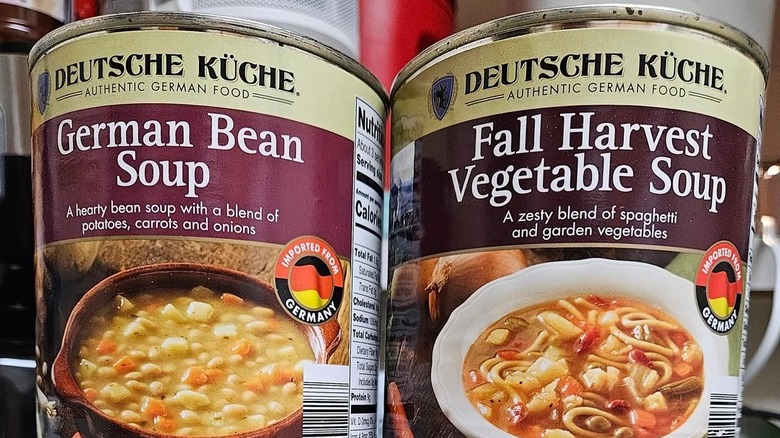 Can of German Bean soup next to can of Fall Harvest Vegetable soup on Aldi shelf