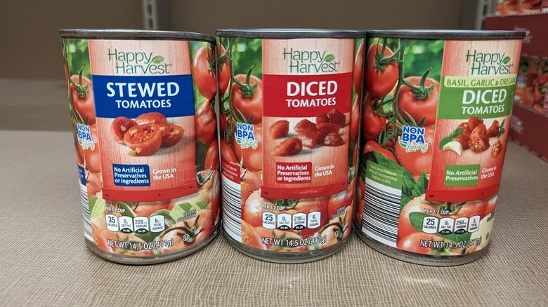 One can each of stewed, diced, and seasoned tomatoes standing side by side