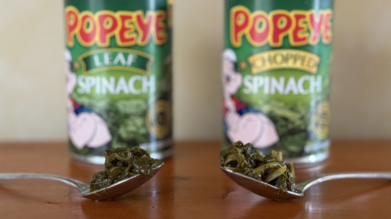 Two spoonfuls of spinach in front of two Popeye cans