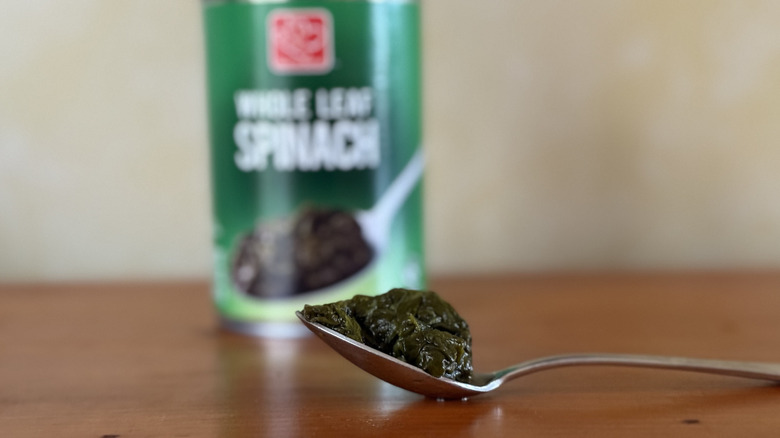 Spoonful of spinach in front of Harris Teeter can