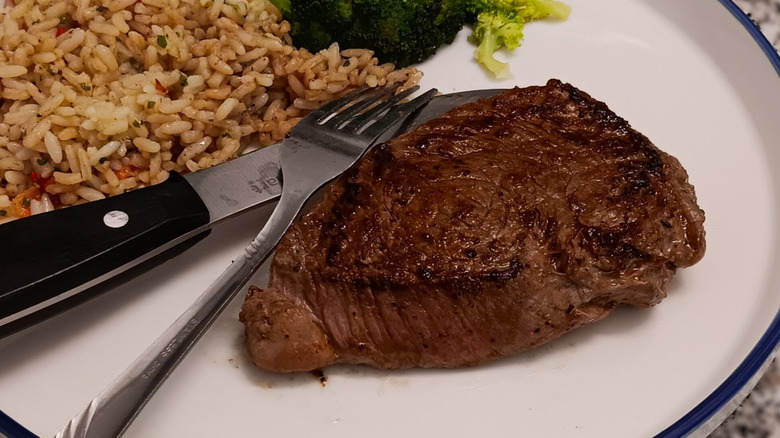LongHorn Steakhouse sirloin with side of rice on white plate with silverware