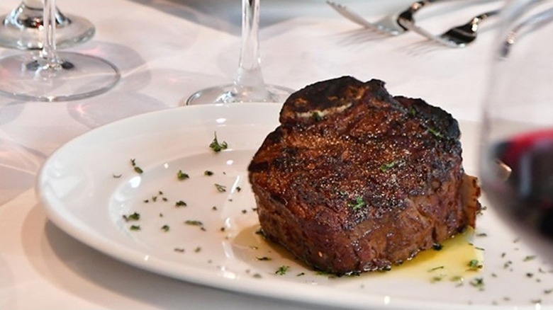 Seared bone-in filet mignon on white plate from Mastro's Restaurants