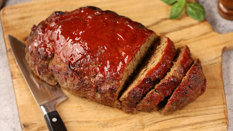 Cooked meatloaf with ketchup glaze on cutting board