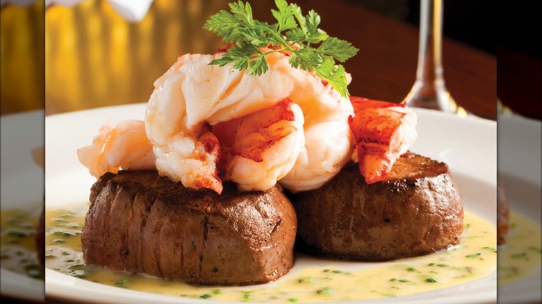 Seared Tenderloin with Butter Poached Lobster Tails on a white plate