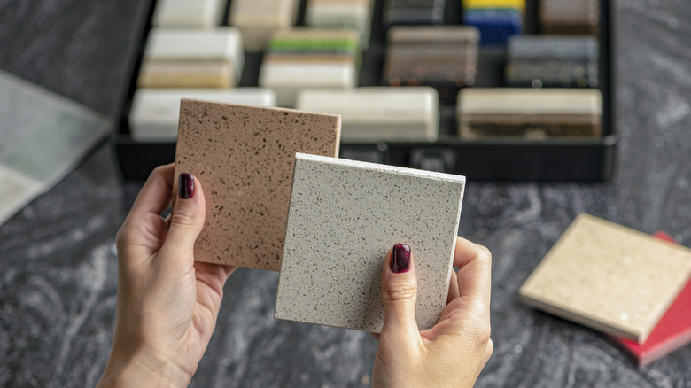 Hands holding sample of materials for kitchen countertop