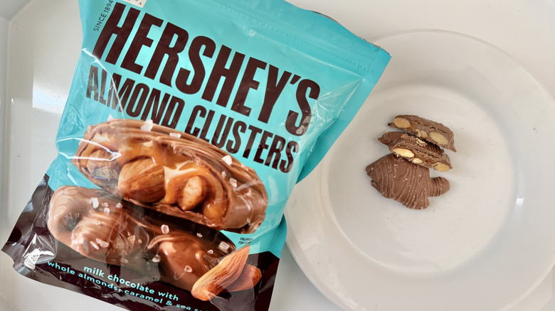 One Hershey's Almond Caramel Cluster cut in half on a plate