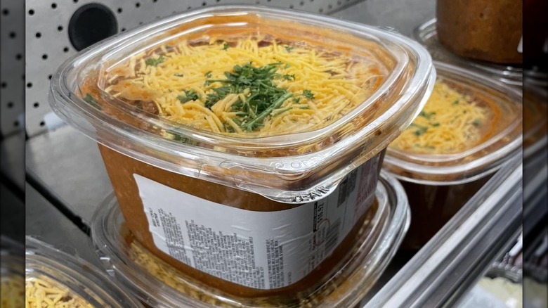 Tubs of Kirkland Signature Beef Chili on display in a Costco warehouse deli case