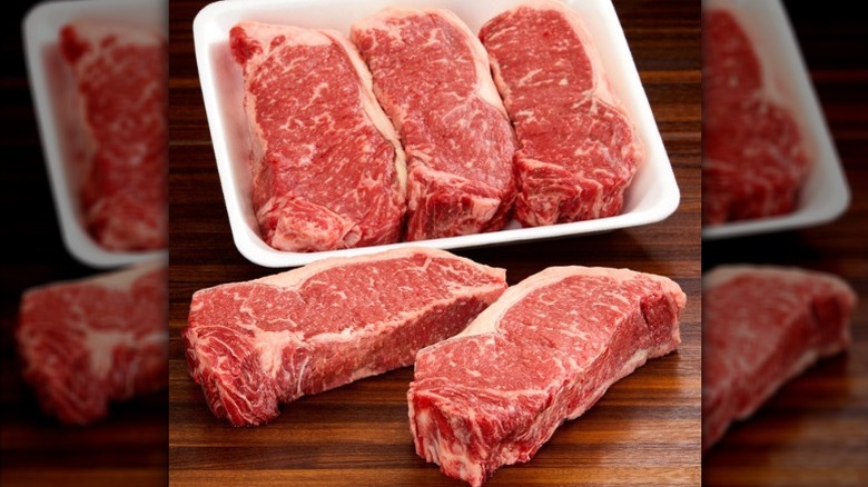 Kirkland Signature USDA Prime New York strip steaks in packaging on a wooden table.