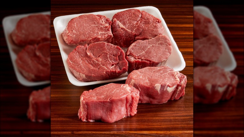 Six Kirkland Signature USDA Choice filet mignon steaks in white Styrofoam package on a table.